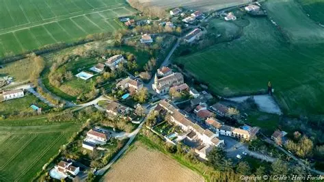 Vue panoramique depuis le ciel de la commune rurale d'Ambres, située dans le Tarn. Vue aérienne du village d'Ambres entouré de champs verdoyants et de terres agricoles.